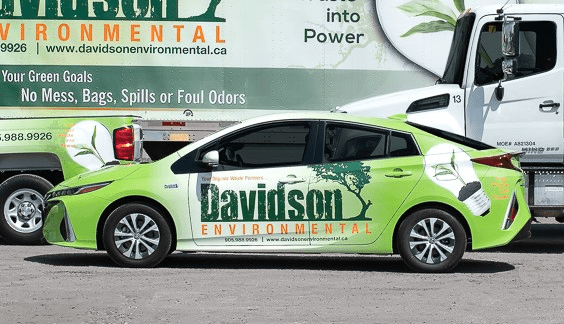 Bright green vehicle branded with "Davidson Environmental," parked beside a truck, promoting eco-friendly services.