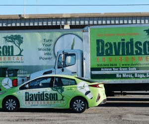 Davidson Environmental vehicles, including a truck and car, showcase branding focused on sustainable waste management and green energy solutions.