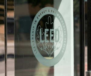 LEED Platinum certification logo displayed on a glass door, signifying high standards in energy efficiency and environmental design.