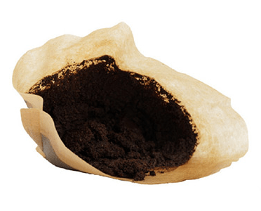 Coffee filter filled with freshly ground coffee, showcasing a rich, dark texture. Ideal for brewing, highlighting the preparation for a flavorful cup.